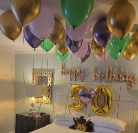 A room with balloons and a bed in it