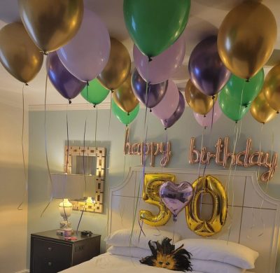 A room with balloons and a bed in it