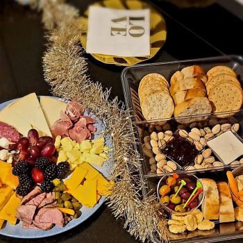 Cheese and charcuterie platter with bread assortment.