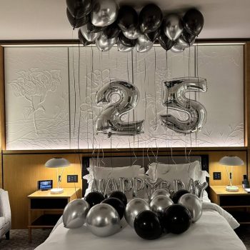 Bedroom with "25" silver balloons decoration.
