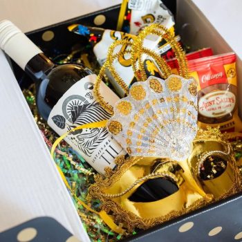Gift box with wine and gold mask.