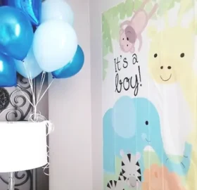 A baby shower with balloons and a poster