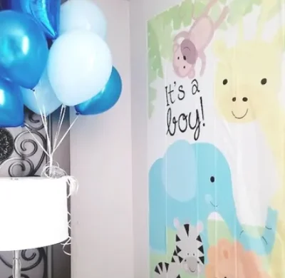 A baby shower with balloons and a poster