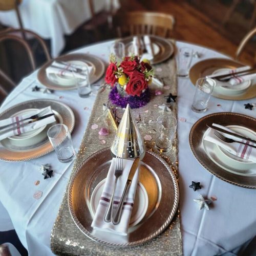 A table set with plates, napkins and silverware.