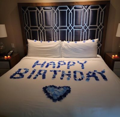 A bed with blue roses on it and the words " happy birthday ".